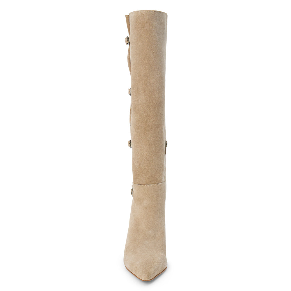 Tan suede knee-high boot with four silver-tone buckle accents, a pointed toe, and slim tan kitten heel shown on a white background.