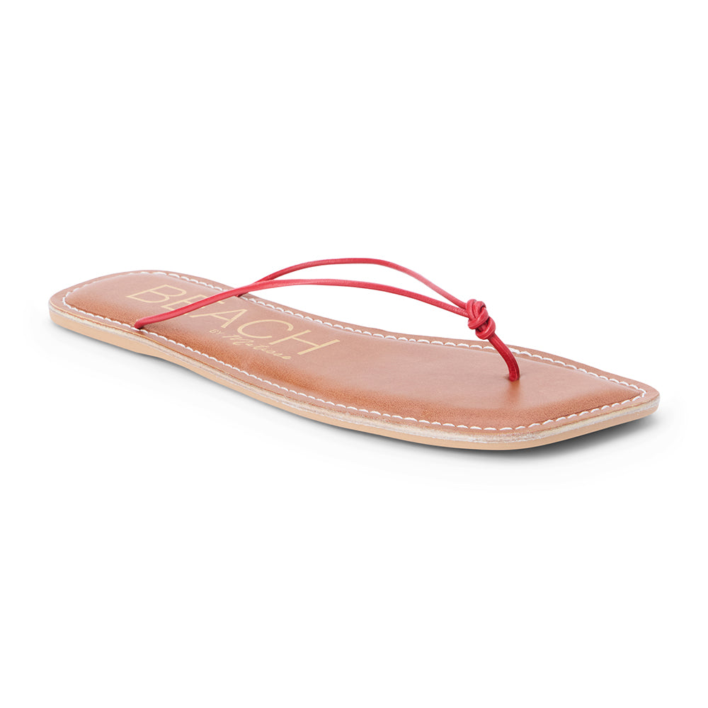 Red leather flat thong sandal with slim knotted straps and square toe, shown on a white background.