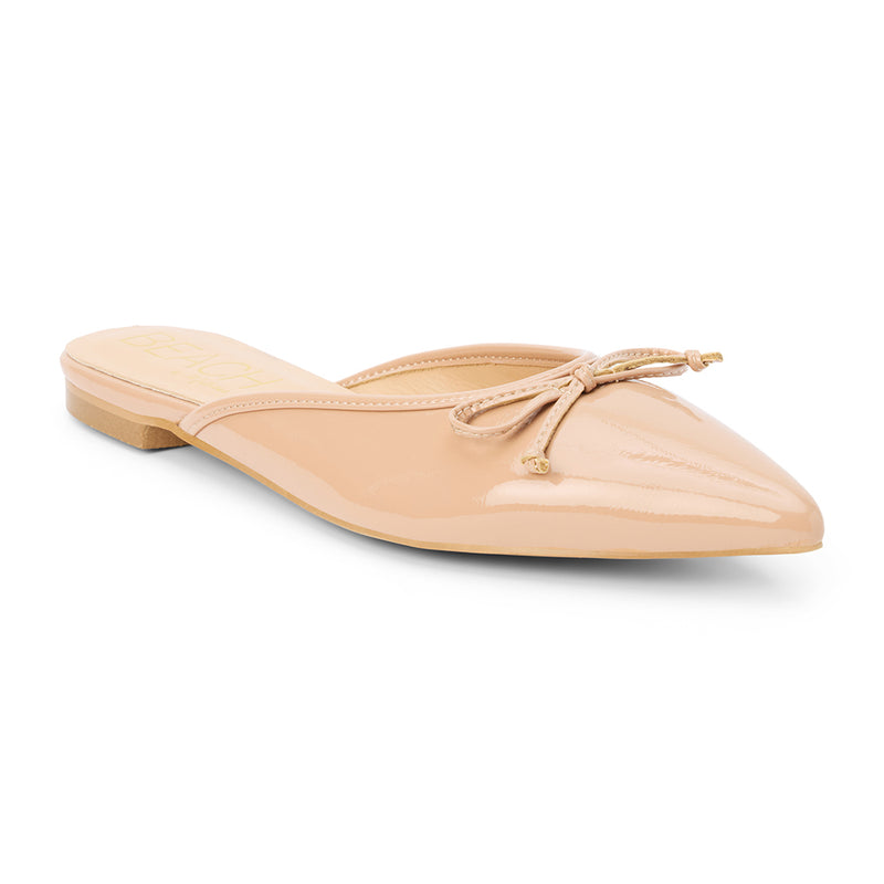 Reggie Vegan Pointed Toe Mule – Beach by Matisse – Beige faux patent leather flat mule with pointed toe and petite bow detail.