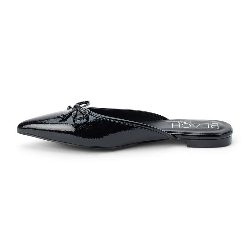 Reggie Vegan Pointed Toe Mule – Beach by Matisse – Black faux patent leather flat mule with pointed toe and petite bow detail.