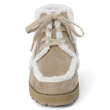 Vegan tan faux suede ankle boot with white faux-fur trim, wraparound lacing, a rounded moc toe, and lug sole shown on a white background.