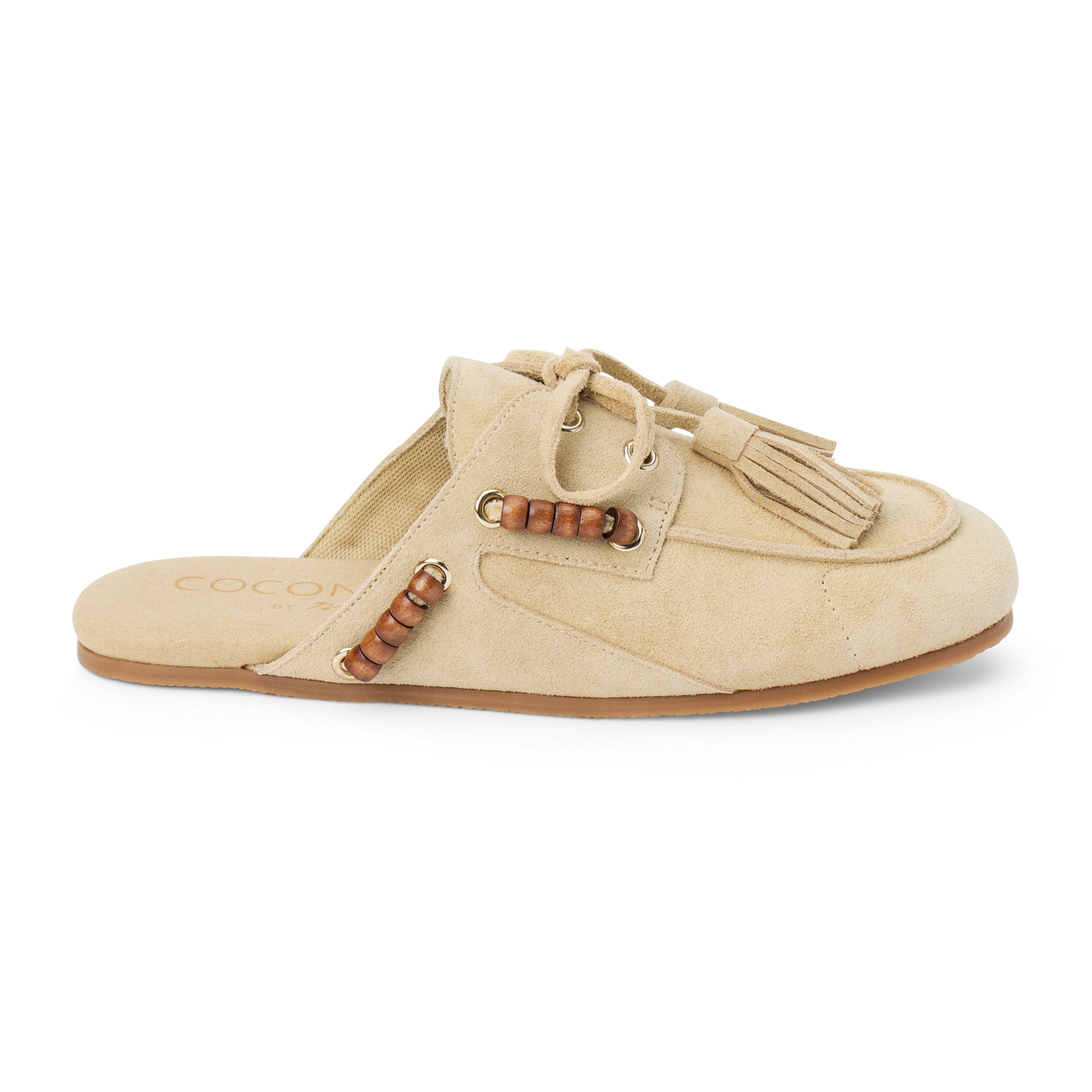 Tan suede mule with an open back, moc-toe stitching, lace-up tassels, wood bead accents, and a flat sole shown on a white background.
