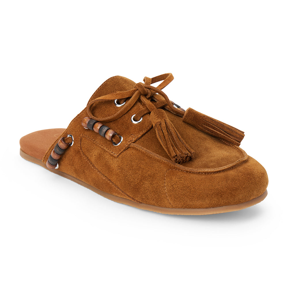 Brown suede mule with an open back, moc-toe stitching, lace-up tassels, contrasting wood bead accents, and a flat sole shown on a white background.