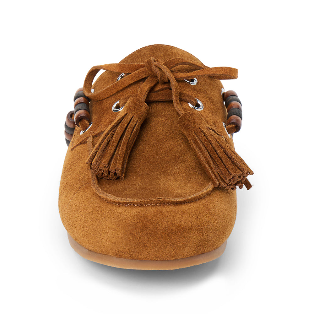 Brown suede mule with an open back, moc-toe stitching, lace-up tassels, contrasting wood bead accents, and a flat sole shown on a white background.