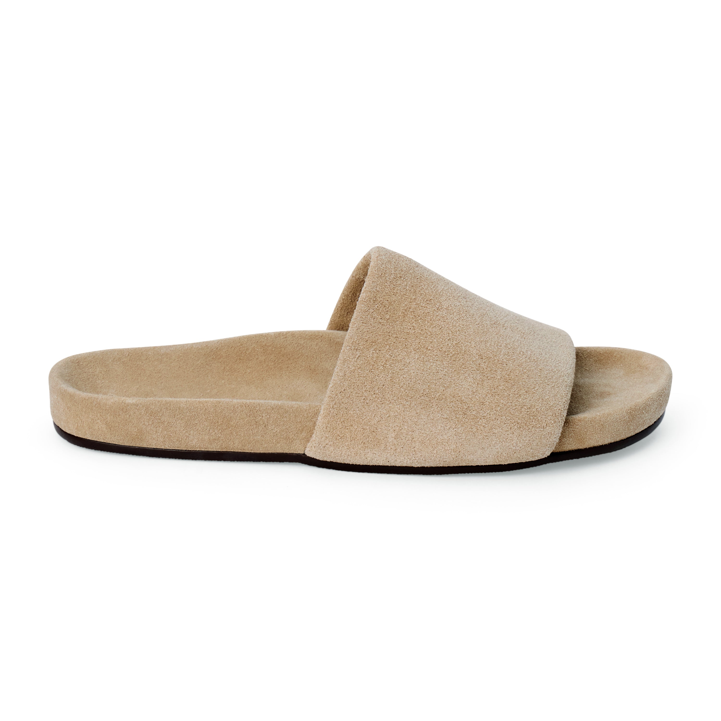 Sand beige suede flat slide sandal with wide strap and molded footbed, shown on a white background.
