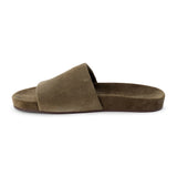 Moss green suede flat slide sandal with wide strap and molded footbed, shown on a white background.