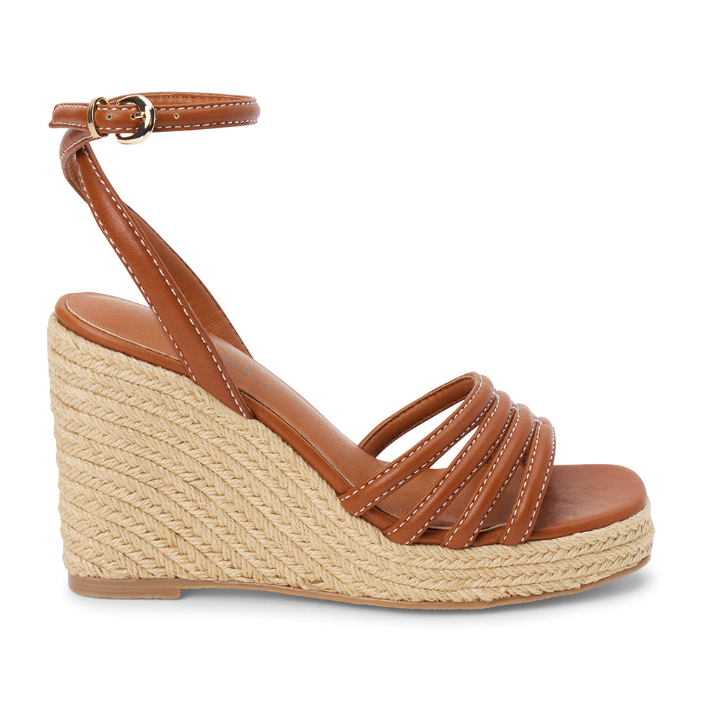 Brown vegan faux leather wedge sandal with ankle strap and braided platform heel shown on a white background.