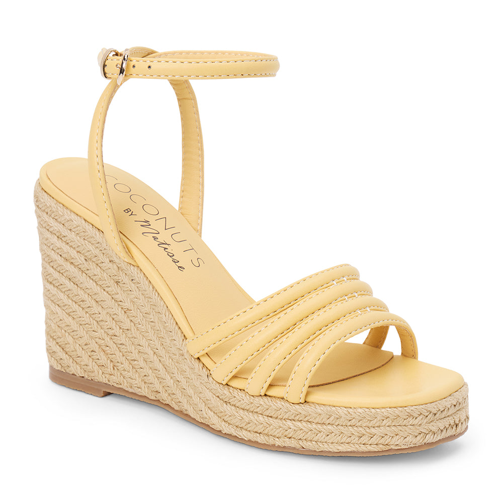 Light yellow vegan faux leather wedge sandal with ankle strap and braided platform heel shown on a white background.
