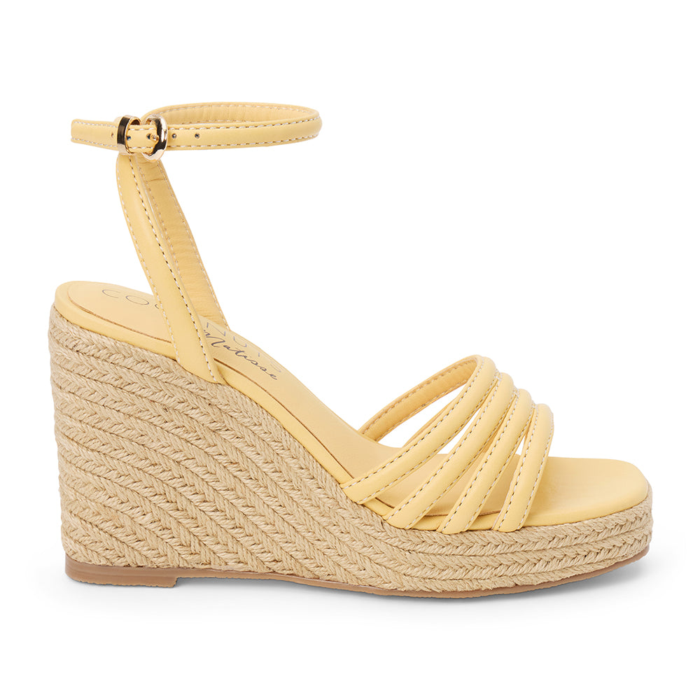 Light yellow vegan faux leather wedge sandal with ankle strap and braided platform heel shown on a white background.