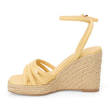 Light yellow vegan faux leather wedge sandal with ankle strap and braided platform heel shown on a white background.