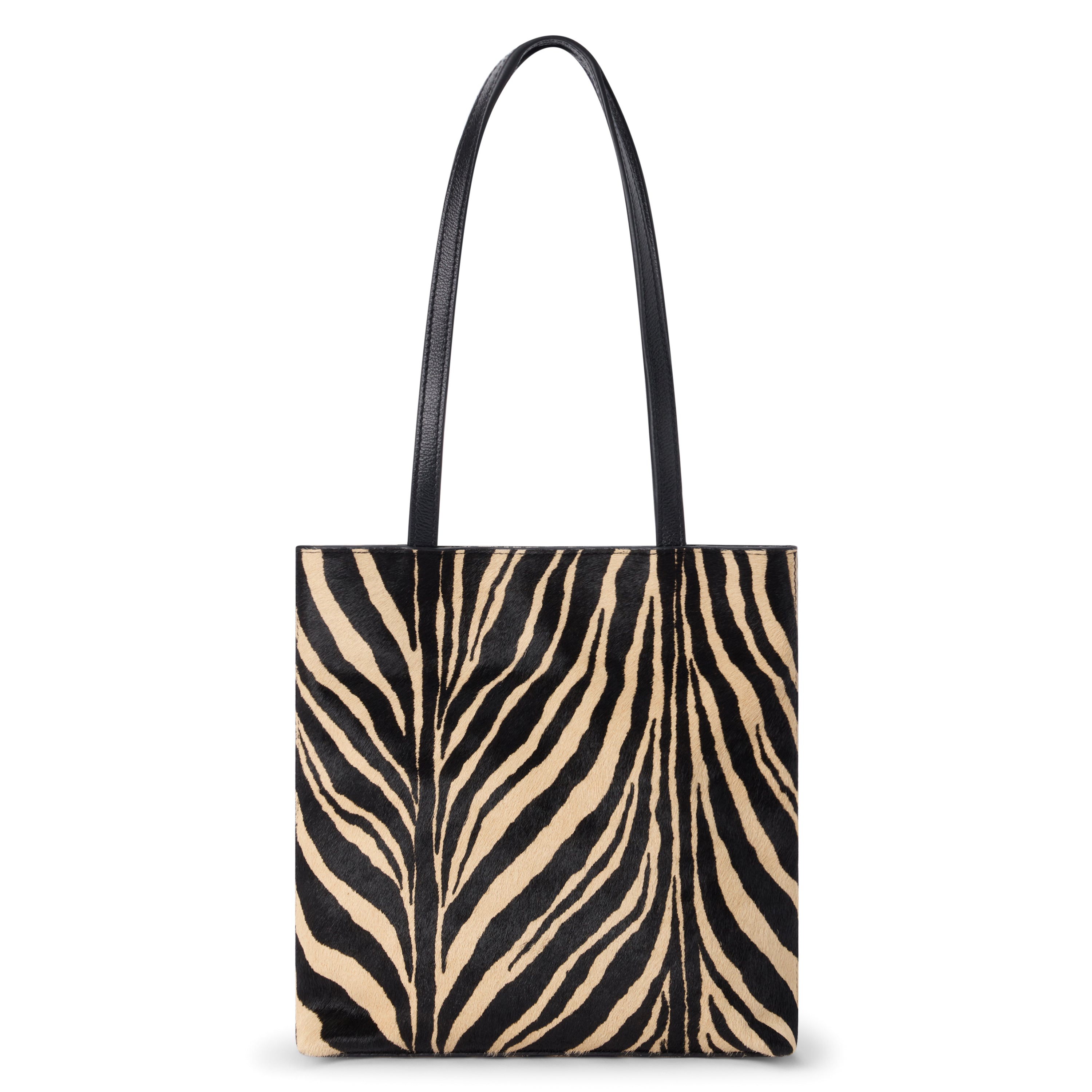 Black and tan cow hair tote bag with a zebra stripe pattern, rectangular body, and two long black shoulder straps shown on a white background.