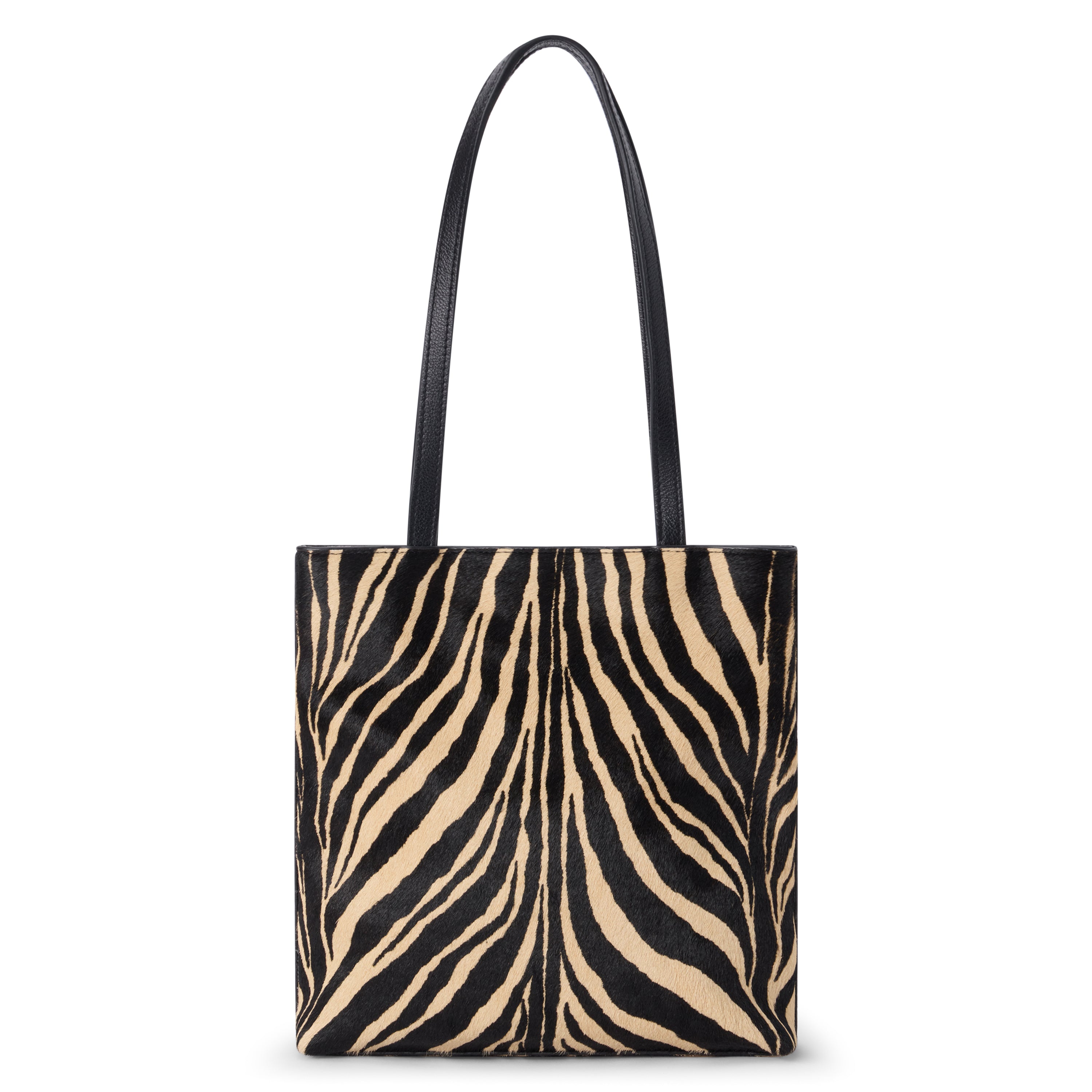 Black and tan cow hair tote bag with a zebra stripe pattern, rectangular body, and two long black shoulder straps shown on a white background.