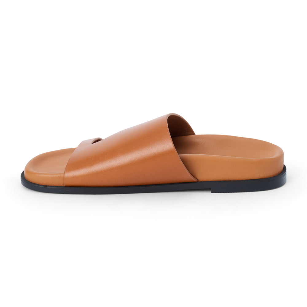 Brown leather slide sandal with wide strap and open toe shown on a white background.