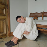 Woman sitting on the floor in a room with wooden furniture.
