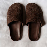 Pair of brown woven mules on a white background
