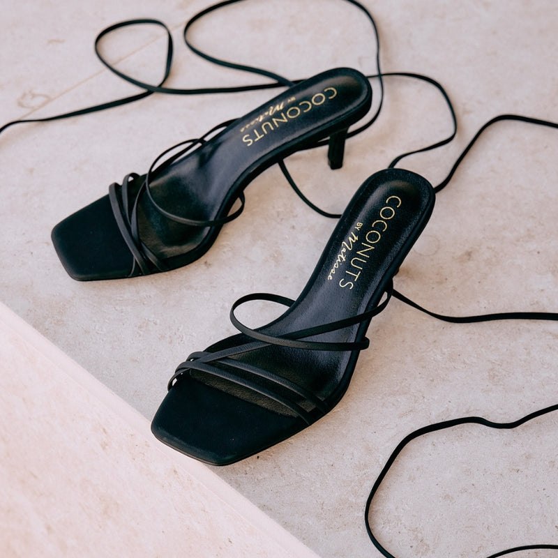 Lilly Heeled Sandal – Coconuts by Matisse – Black strappy sandal featuring a delicate square toe, slender wraparound ankle ties, and a flared kitten heel. An effortlessly sleek silhouette for day-to-night styling.