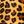 Close-up of a leopard print fabric pattern with black and dark brown spots on a warm tan background.