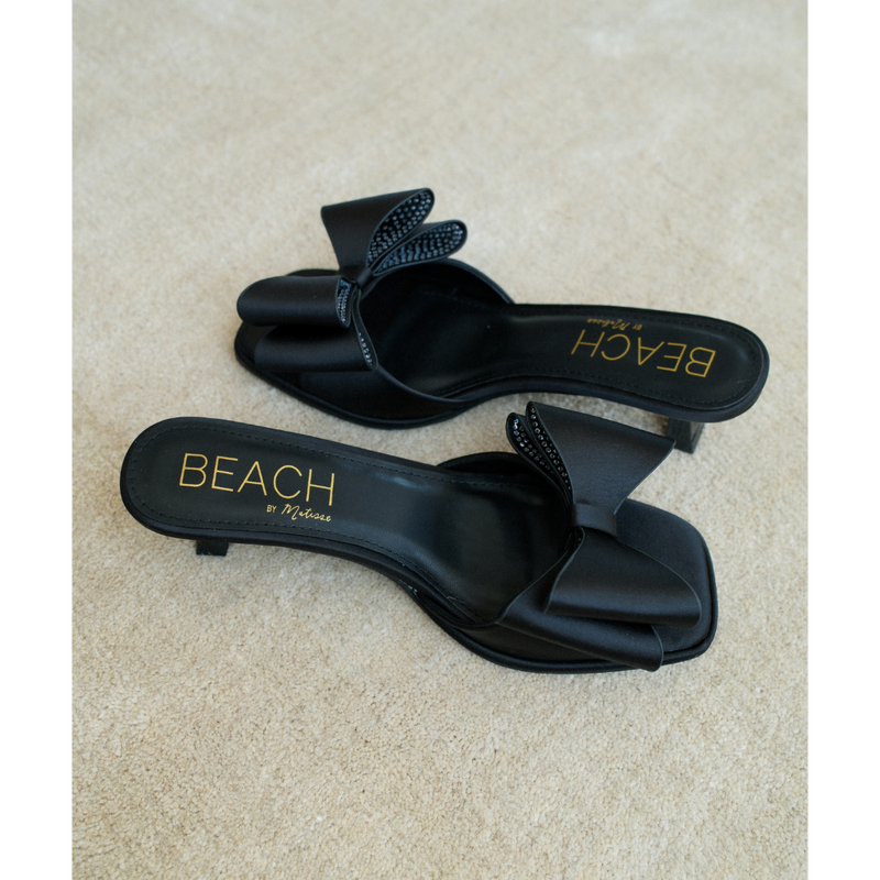 Holland Vegan Heeled Sandal – Beach by Matisse – Black satin slip-on sandal with kitten heel and oversized double bow detail.