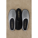 Pair of mesh slip-on shoes in white and black with 'Matisse' branding on a beige carpet.
