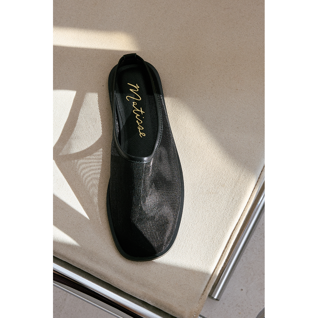 Black mesh slip-on shoe with 'Matisse' branding on a light surface.