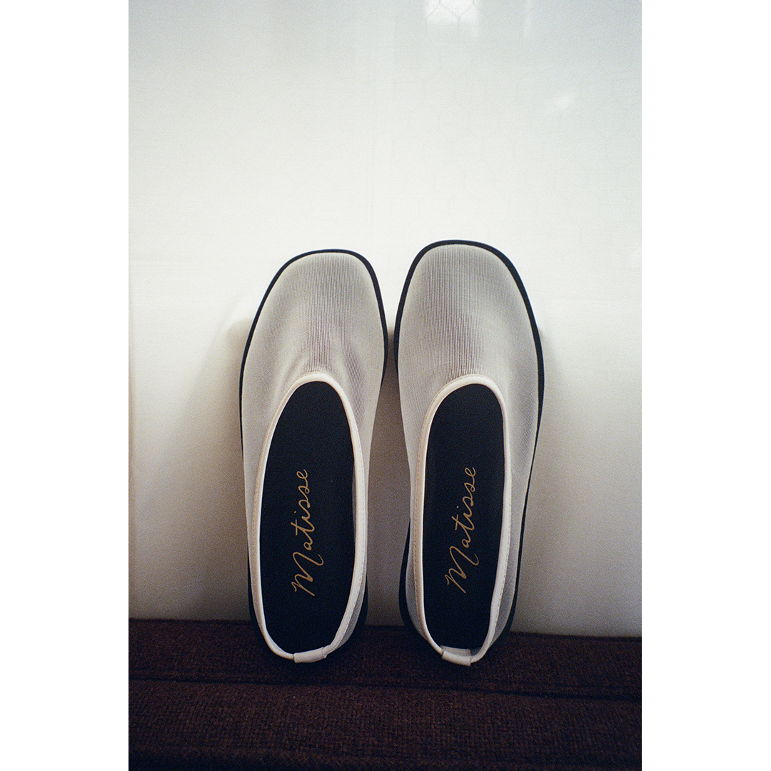 Pair of white mesh slip-on shoes with black soles on a white background, featuring 'Matisse' branding.