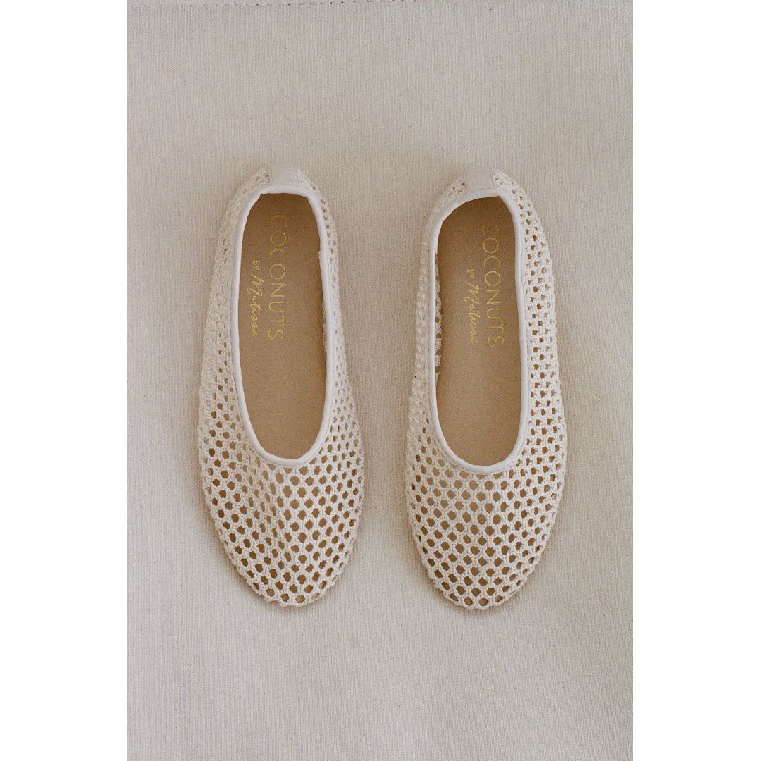 Pair of beige woven ballet flats on a light gray background.