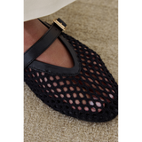 Close up shot of the black woven Nolita Ballet Flat on a beige carpet.