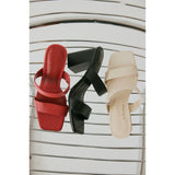Three women's heeled sandals in red, black, and beige on a striped background.