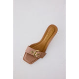 Beige sandal with a strap and gold buckle on a light gray background, branded 'Coconuts by Matisse'.