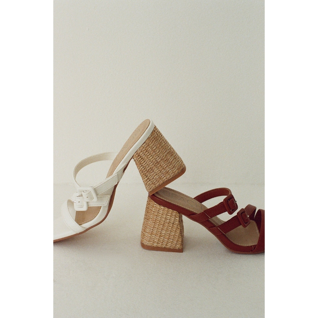 Two high-heeled sandals with woven design on a light background.