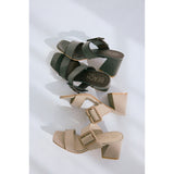 Pair of brown and beige high-heeled sandals on a white background.