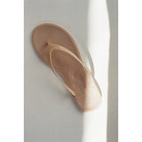 Beige flip-flop sandal on a light gray background.