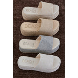 Four pairs of 'Beach by Matisse' sandals in different patterns on a brown carpet.