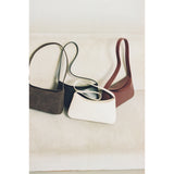 Four handbags in different colors on a light background.