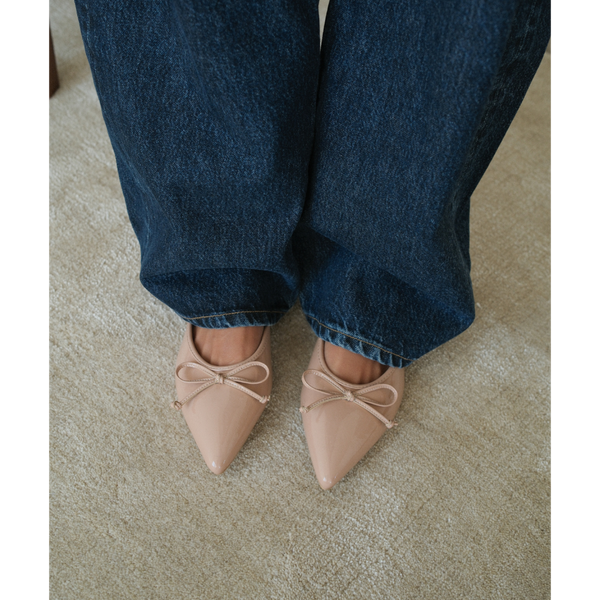 Reggie Vegan Pointed Toe Mule – Beach by Matisse – Beige faux patent leather flat mule with pointed toe and petite bow detail.