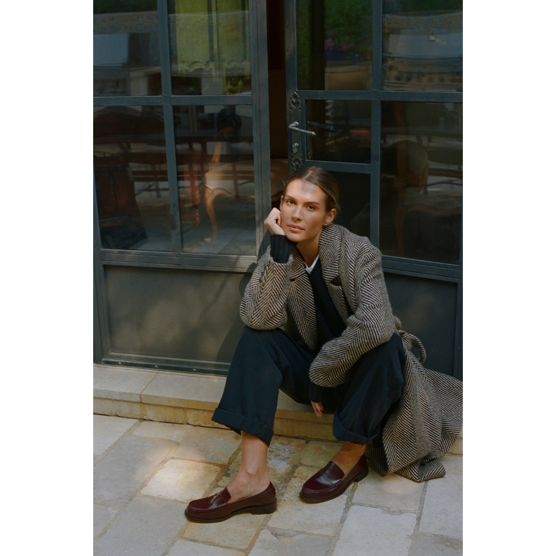 Burgundy leather penny loafers with a polished finish, classic moccasin stitching, and a low stacked heel. A timeless staple for effortless sophistication.