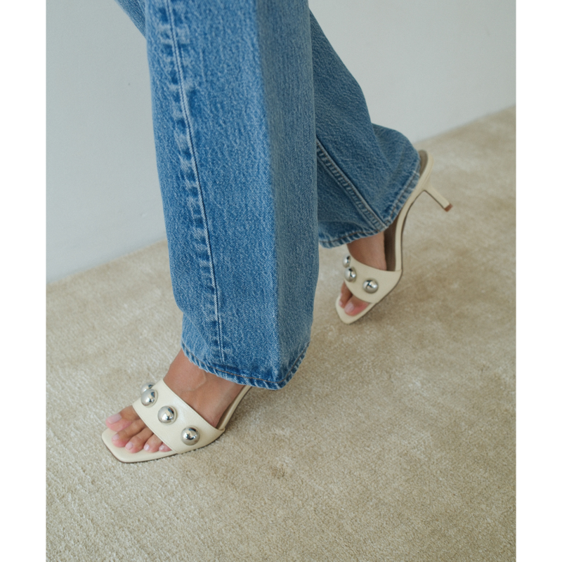 Theo Heeled Sandal – Coconuts by Matisse – Cream-colored slip-on sandal with square toe, silver dome embellishments, and tapered heel.