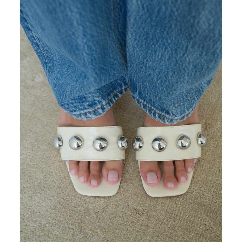 Theo Heeled Sandal – Coconuts by Matisse – Cream-colored slip-on sandal with square toe, silver dome embellishments, and tapered heel.