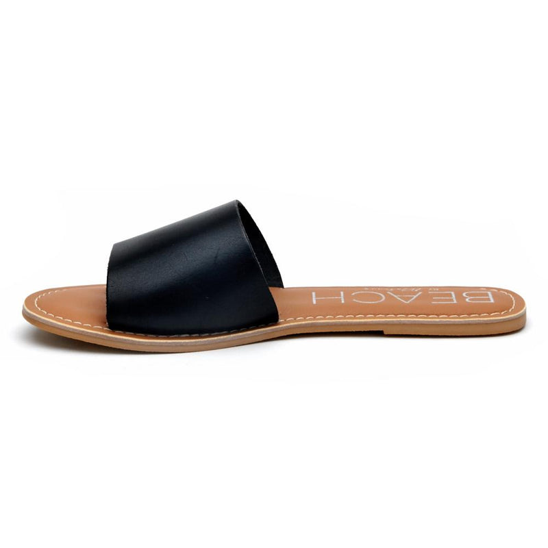A minimalist essential, these black leather slide sandals feature a wide single strap and a flat sole. A versatile slip-on design perfect for effortless everyday wear.