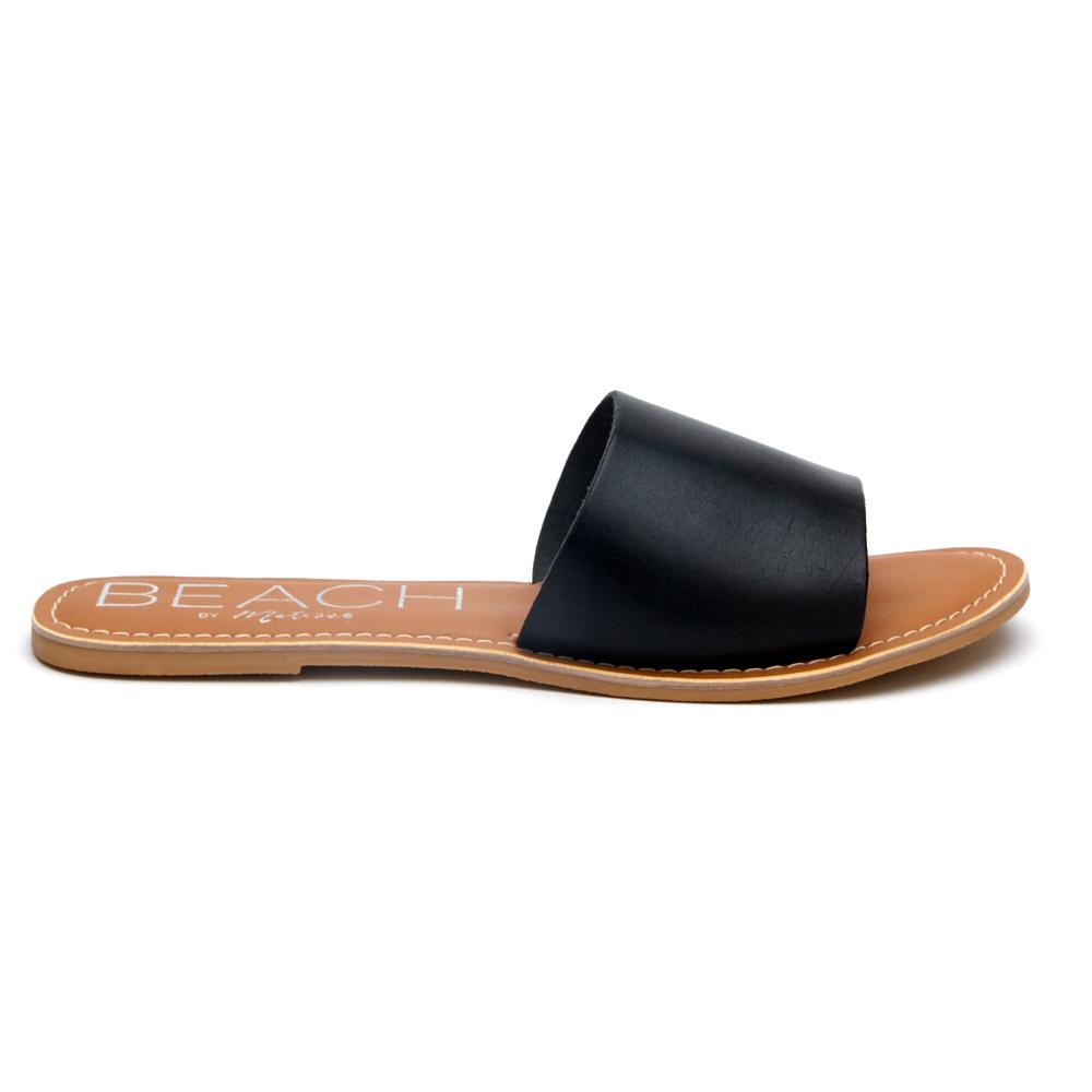 A minimalist essential, these black leather slide sandals feature a wide single strap and a flat sole. A versatile slip-on design perfect for effortless everyday wear.